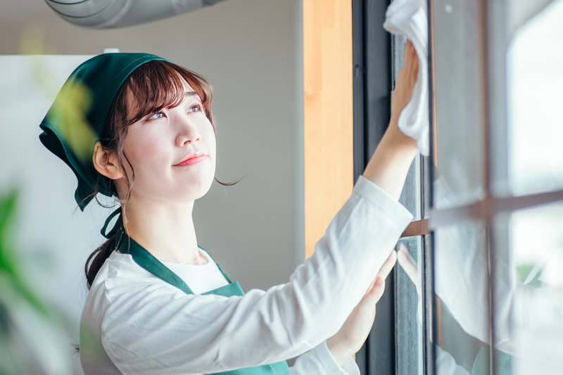 窓拭き掃除をする女性