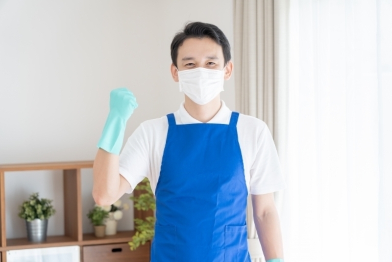 エプロンをつけてガッツポーズをする男性